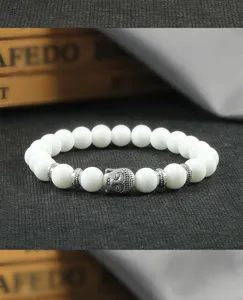 Weißes Perlenarmband mit Legierungsabstandshaltern und Buddha Kopf Anhänger im Detail.