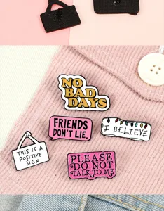 Close-up view of creative enamel pins featuring funny english quotes, alloy metal badge set.