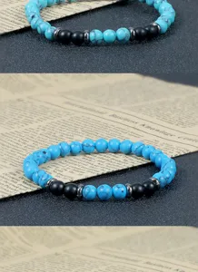 Close-up detail van de turquoise en zwarte kralen armband met metalen tussenliggende kralen.