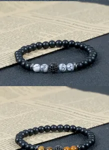Detailopname van kralenarmbanden met matte zwarte stenen en mooie gemarmerde kralen.