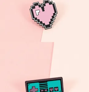 Primer plano detallado que muestra un corazón de píxeles y un broche de mando de juegos.