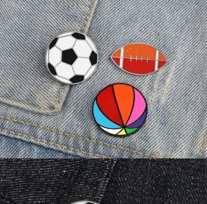 Detailed view of alloy sports pins, featuring soccer and rugby brooches on denim.