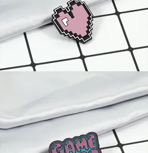 Vista detallada de broches de metal con corazón píxel y letras, diseño rosa, calidad.