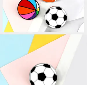 Close-up detail of sports alloy brooch, mini football and colorful ball pin for denim.