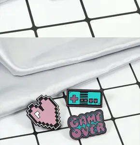 Bonito set de broches esmaltados en rosa con diseño retro pixel digital game over.