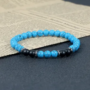 Turquoise en zwarte kralen yoga elastische armband voorzien van legering afstandhouders.