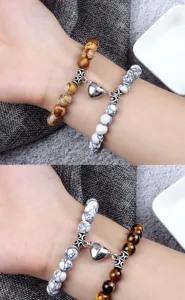 Gros plan détaillé de bracelets de couple assortis avec cœur magnétique et perles.