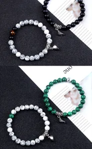 Vue détaillée de bracelets de perles de couple magnétiques créatifs avec pendentifs cœur.