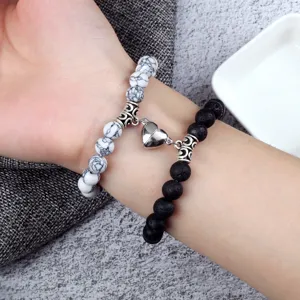 Ensemble de bracelets de couple magnétiques en pierre de lave noire et perles blanches.