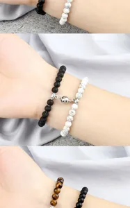 Close-up detail of magnetic couple beaded bracelets with black lava and white stone.