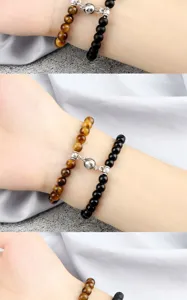 Detail view of magnetic couple bracelets featuring tiger eye and black stone beads close up.