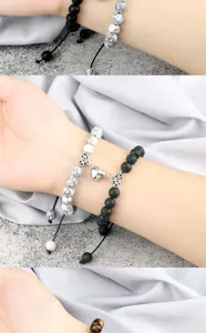 Detailed shot of couple magnetic heart bracelets with black lava and white stone beads.