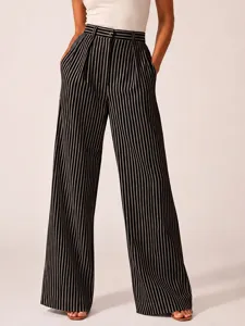 Detailed view of women's black and white striped wide leg trousers with high waist design.