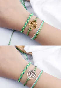 Primo piano di braccialetti dell'amicizia intrecciati a mano con ciondolo albero della vita.