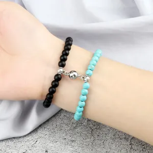 Couple magnetic attraction beaded bracelet set with black and turquoise stone beads on wrist.