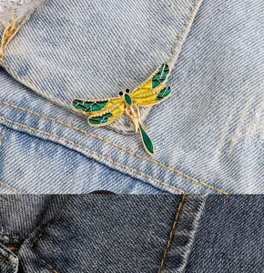 Close-up detail of a charming dragonfly enamel brooch, perfect for collar or bag decoration.
