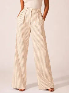 Detailed view showcasing the high-waisted striped wide-leg trousers with a relaxed fit.
