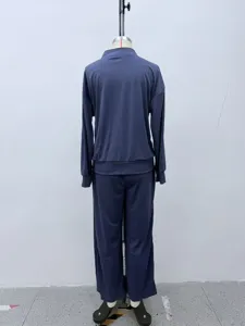 Detailed view of the solid mock neck track jacket and wide leg pants set back side.