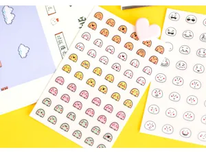 Close-up detail shot of cute cartoon emoji stickers sheet for planner and diary decoration.