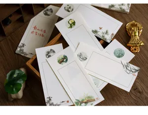 Juego de papel de carta de estilo chino tradicional con arte botánico y caligrafía fina.