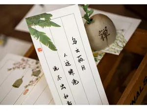 Primer plano detallado de papel de carta chino vintage con caligrafía elegante y diseños florales.
