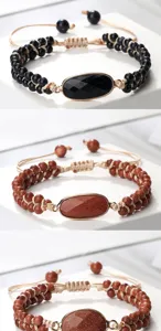 Gros plan de bracelets de perles à double rang avec pierres précieuses et cordons ajustables.