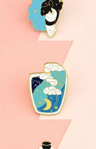 Artistic enamel pin detail showing creative wave and paint tube designs with gold plating.