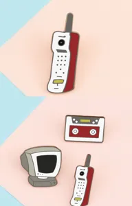 Vista dettagliata di spille smaltate retro tech, classico badge di telefono cassetta e computer.
