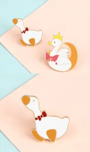 Close-up detail of cute cartoon duck and swan enamel alloy brooches, exquisite lapel pins decoration.