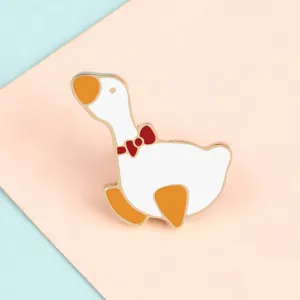 Cute cartoon white duck enamel brooch, stylish alloy badge pin with red bow for apparel decor.