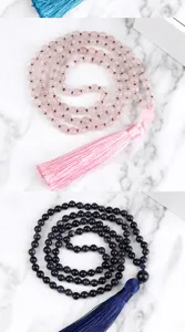 Primer plano detallado de pulseras de cuentas de piedras preciosas con borlas rosas y azules.