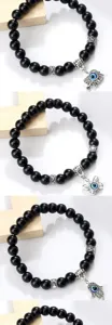 Bracelet de perles noires avec pendentifs œil protecteur et intercalaires argentés élégants.