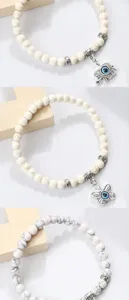 Gros plan des détails du bracelet de perles avec mauvais œil et espaceurs argentés fins.