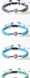 Détails en gros plan du bracelet tressé en perles avec œil turc et strass brillants.