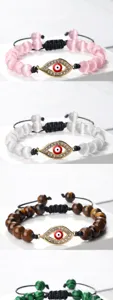 Gros plan des détails du bracelet tressé en perles avec breloque mauvais œil réglable.