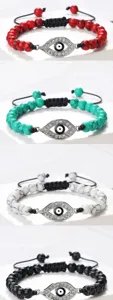 Gros plan détaillé du bracelet pendentif œil turc avec perles craquelées et cordon noir.
