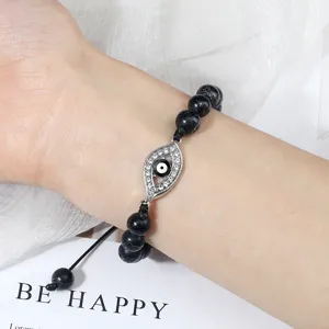 Bracelet de perles noires avec pendentif œil maléfique et zirconias, cordon ajustable tressé.