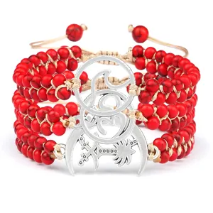 Bracelet de perles de pierre rouge multicouche avec pendentifs en métal argenté.