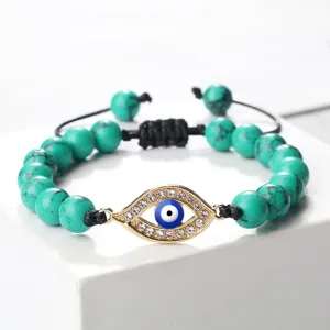 Bracelet de perles turquoise bohème avec pendentif œil maléfique en strass doré et cordon réglable.