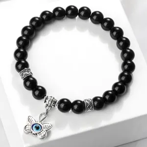 Bracelet de perles noires avec pendentif œil maléfique papillon et perles d'espacement argentées.
