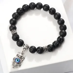 Bracelet en perles de pierre de lave noire mate avec pendentif hibou œil maléfique.