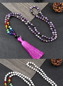 Détail de long collier de perles bohème montrant des pierres chakra colorées et beau pompon.