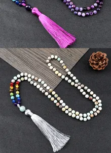 Gros plan détaillé de collier de méditation bohème multicolore à 108 perles avec beaux pompons.