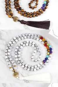 Detailed view of multi-layer beaded necklaces featuring tiger eye and chakra stones with tassels.