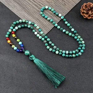 Collier de perles vertes bohème avec pierres chakra colorées et pendentif gland élégant.