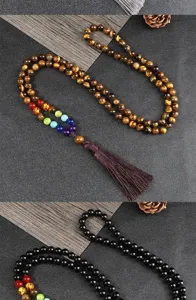 Dettaglio della lunga collana con pietre chakra in occhio di tigre e ossidiana con nappina.