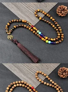 Dettaglio della collana di perle chakra in occhio di tigre con pietre e albero della vita.