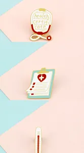 Detailed view of creative medical enamel pins featuring stethoscope, clipboard and thermometer designs.