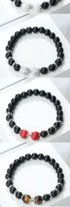 Bracelet en perles noires mates avec pierres centrales colorees et anneaux de rehausse details.