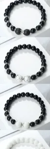 Détail du bracelet de perles avec des perles noires, des intercalaires et des pierres.